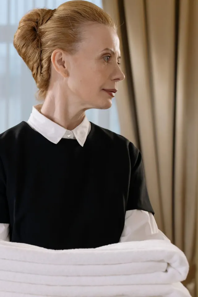 A hotel housekeeper carrying fresh folded towels